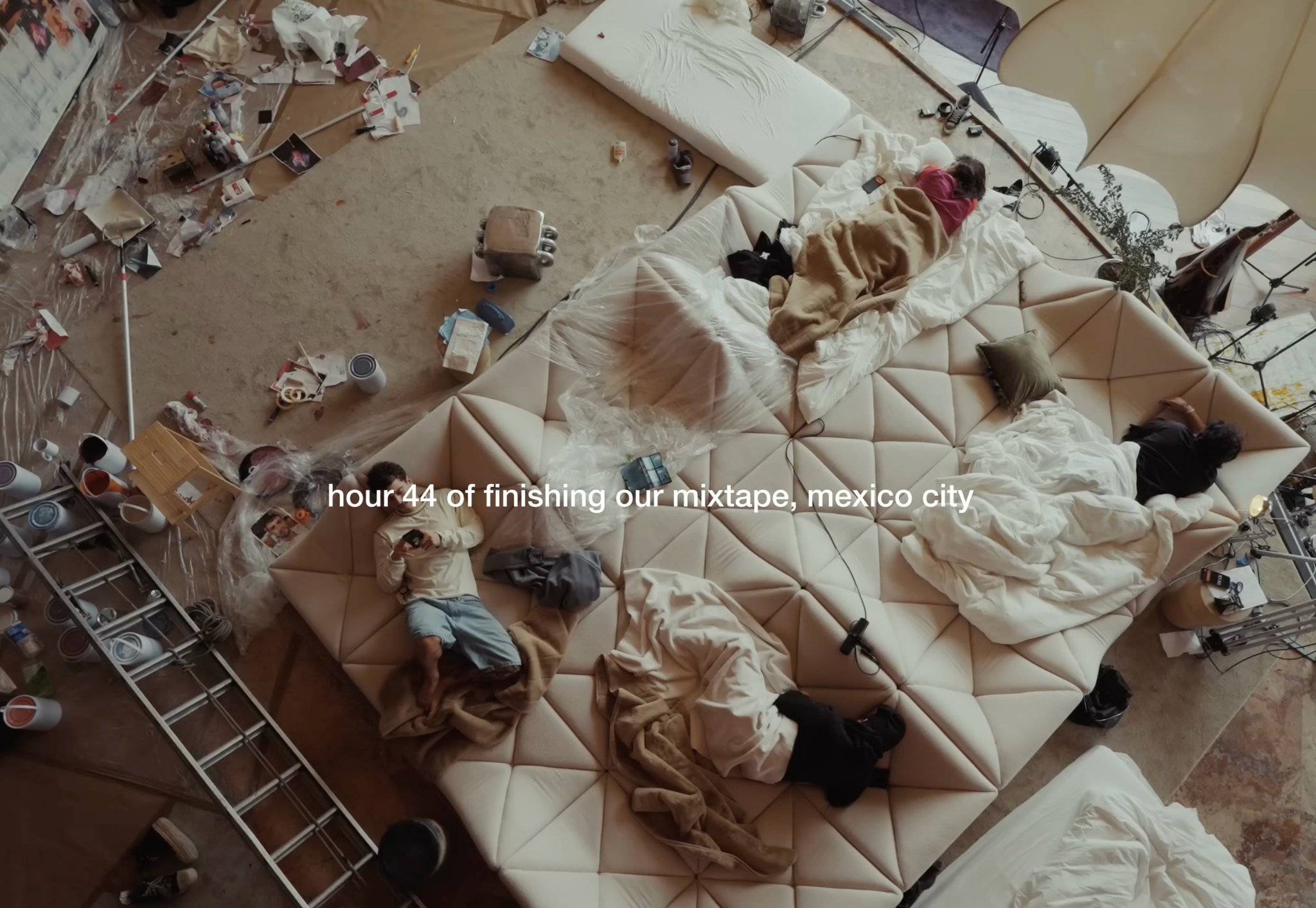 Overhead view of four people in a room, mid-project, surrounded by the mess of finishing something together.